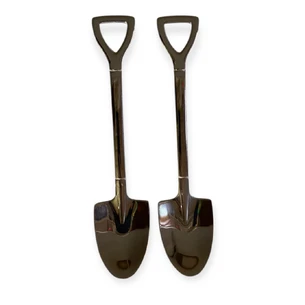 Декоративная ложка в форме лопаты серебристого цвета.